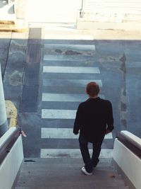 Rear view of man standing on steps