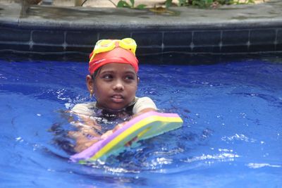 Girl looking away while swimming in pool