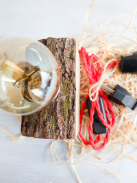 Close-up of light bulb on wood against white background