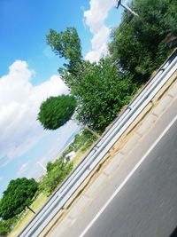 Road by trees against sky seen through window