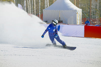 Full length of man skateboarding on snowy field during winter