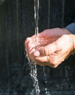 Cropped hands holding water