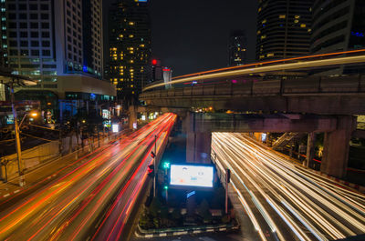 Light trails on road along buildings at night