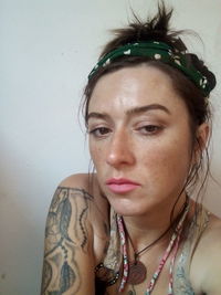 Close-up portrait of young woman against wall