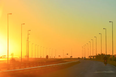 Road in city against clear sky during sunset