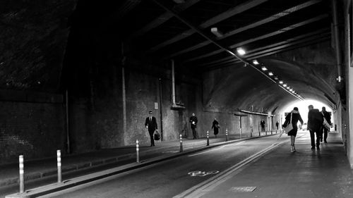 People walking on road in tunnel