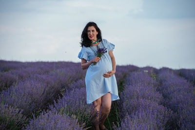 Full length of woman standing on field against sky