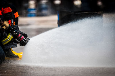 Low section of firefighter spraying water