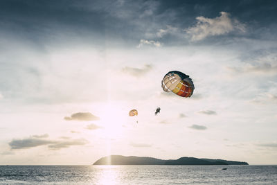 People paragliding over sea against sky