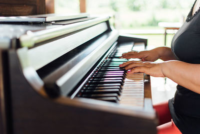 Midsection of woman playing piano