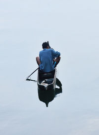 Man sitting in boat on sea