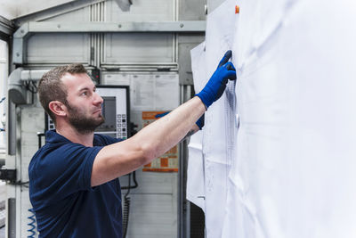 Man looking at plan in industrial factory