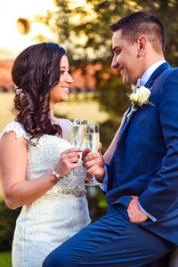 Smiling bridal couple toasting champagne flutes