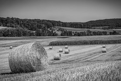 Hay bales on field against sky