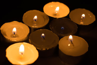 Close-up of lit tea light candles on table