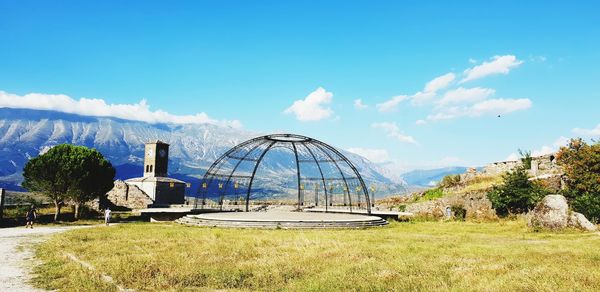 Ferris wheel on field against sky