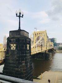 View of bridge over river against cloudy sky