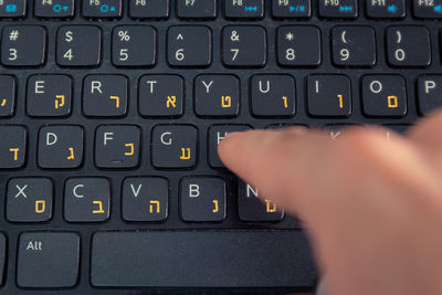 Cropped hand of person using laptop