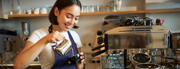 Side view of young woman holding camera