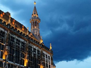 Low angle view of illuminated building against cloudy sky