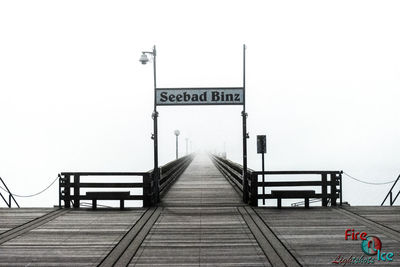 Information sign on bridge against sky