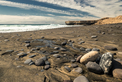 Rocks on shore at beach against sky, punta guadalupe und playa del viejo rey