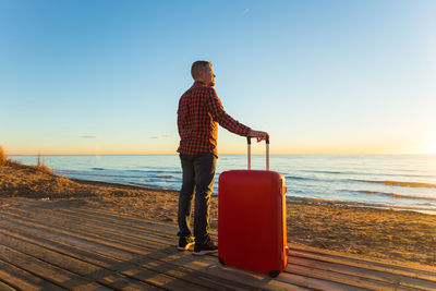 Full length of man on beach against clear sky