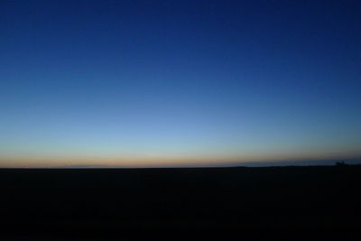 Silhouette landscape against clear blue sky