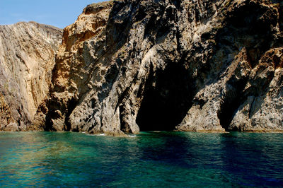 Rock formations by sea against sky