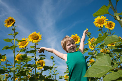 Full length of boy on sunflower against sky