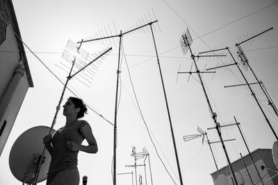 Low angle view of man using mobile phone against sky