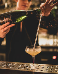 Close-up of hand pouring wine in glass