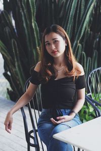 Portrait of young woman sitting outdoors
