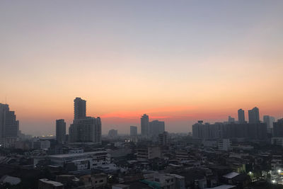 Modern buildings against sky during sunset