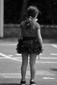 Rear view of girl standing on road