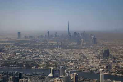 Aerial view of buildings in city against clear sky