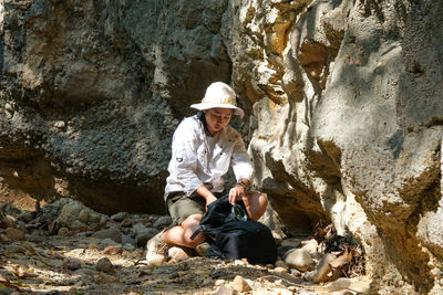 Young man sitting on rock