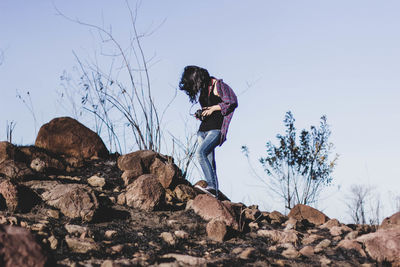 Low angle view of woman standing on field against sky