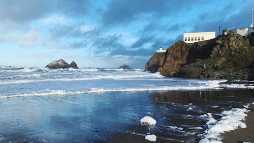 Scenic view of rocks on beach against sky