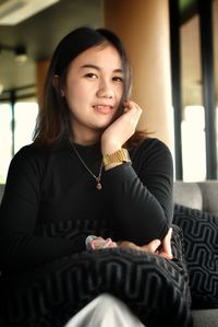 Portrait of smiling woman sitting at home