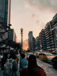 People on city street amidst buildings against sky