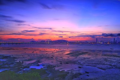 Scenic view of sea and city against romantic sky at sunset