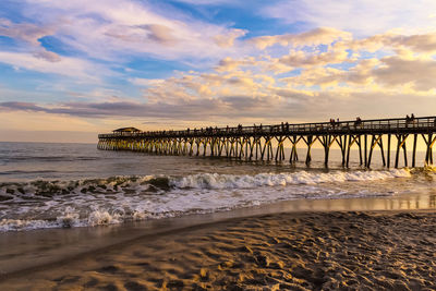 Pier over sea against sky during sunset