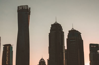 Low angle view of skyscrapers against sky during sunset