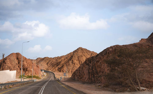 A road next to a mountainous desert landscape. road 12 on the way to eilat, israel, on the egyptian