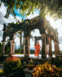 Rear view of people outside temple against building