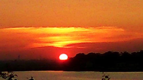 Scenic view of landscape against orange sky