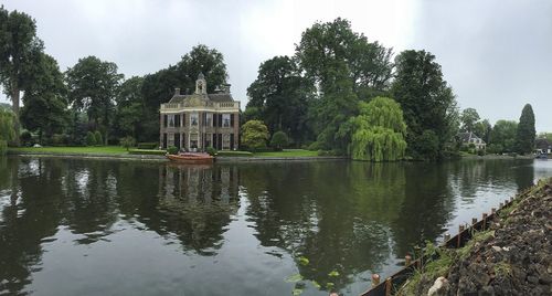 Scenic view of lake by trees against sky
