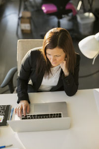 High angle view of businesswoman working on laptop at desk