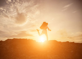 Silhouette person standing on mountain against sky during sunset